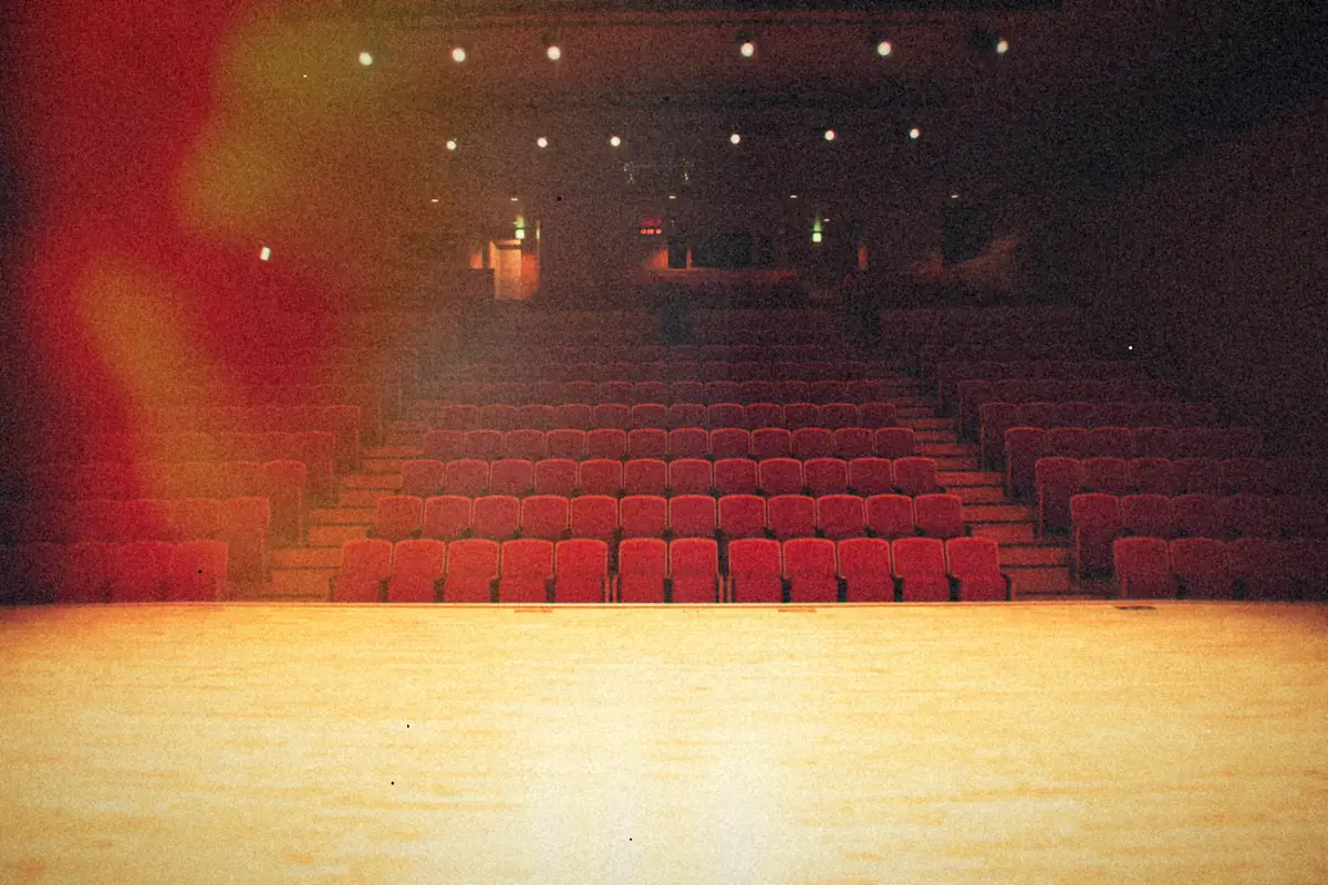 Rows of empty red seats, seen from the stage.