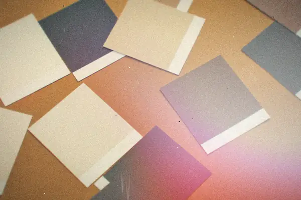 Paint color swatch cards scattered on a brown paper surface.