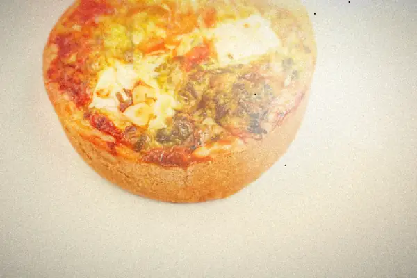 A small individual quiche with spinach, roasted tomato and white cheese.