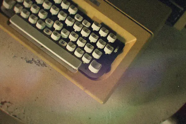 The keys of a cream-colored vintage typewriter on a rustic table.