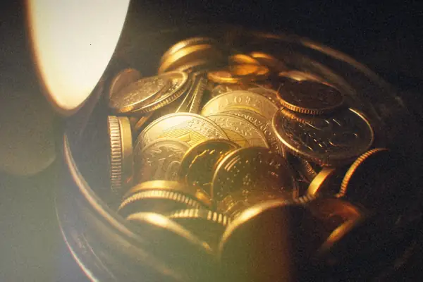 A jar of coins glowing under a warm lamp.