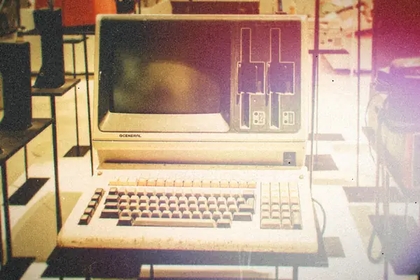 An old beige computer with a built-in monitor, disk slots and keyboard on display.
