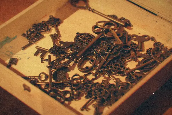 A wooden box full of old brass keys.