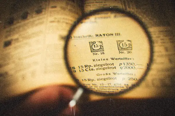 A magnifying glass held over the page of an old open book.