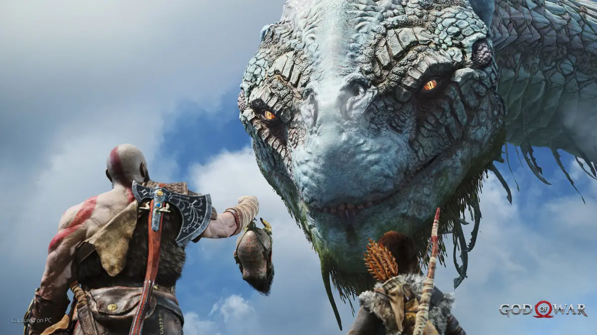 Kratos and his son standing in front of an enormous serpent rising out of a lake in God of War.