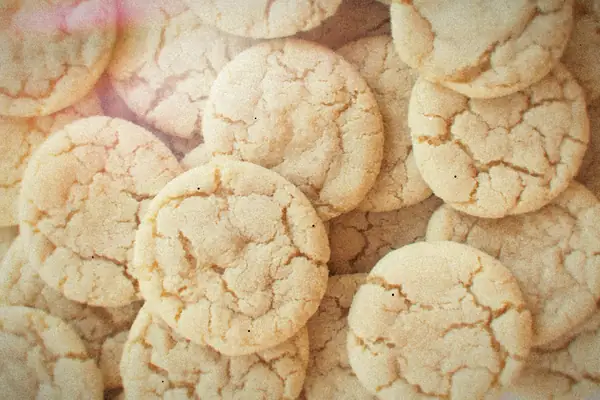 A pile of homemade sugar cookies with crackled tops.