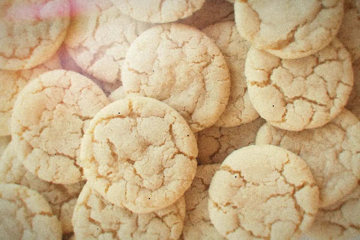 A pile of homemade sugar cookies with crackled tops.