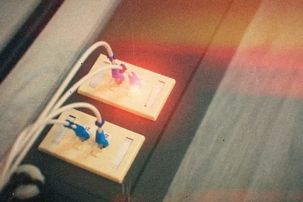 Network cables plugged into two wall jacks, one of them glowing red.