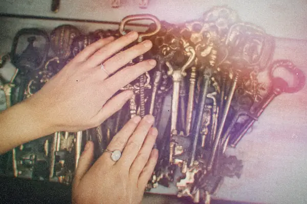 Hands spread over a big pile of old skeleton keys.