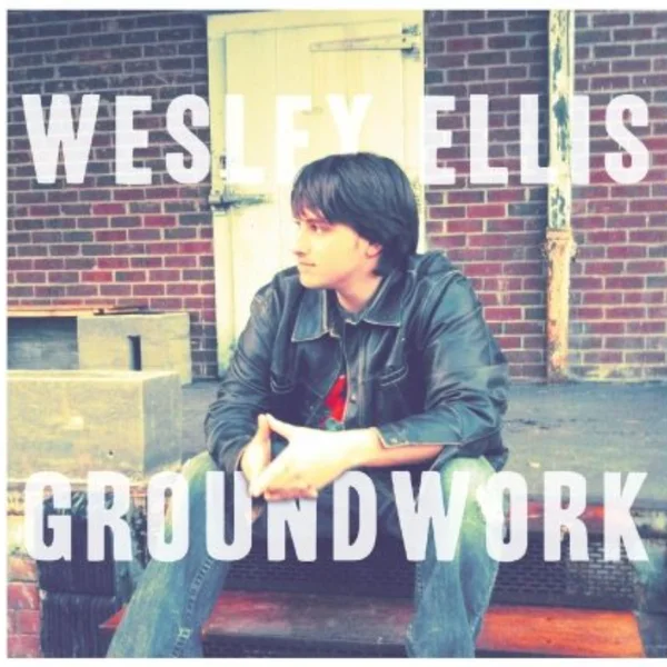 The GROUNDWORK album cover: Wes sitting on loading-dock steps in a leather jacket, the title in big white letters across a brick wall.